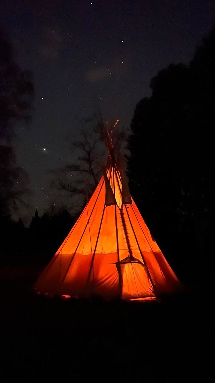 Tipi leuchtend bei Nacht